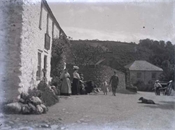Glass negative of scene outside possibly an inn, with people.