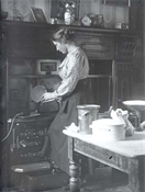 Glass negative of Pollie Baker making a Christmas cake