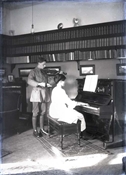 Glass negative of Baker son and daughter at the piano