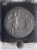 Glass negative of medal awarded to Harry Baker