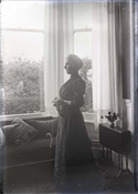 Glass negative of Pollie Baker in front of window at Epworth House.