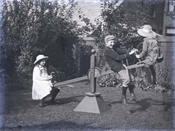 Glass negative of Baker children playing on see-saw