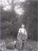 Glass negative of man with rope, in garden at Beaconfield.