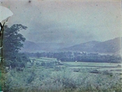 Glass plate, coloured, of view of countryside, towards hills.